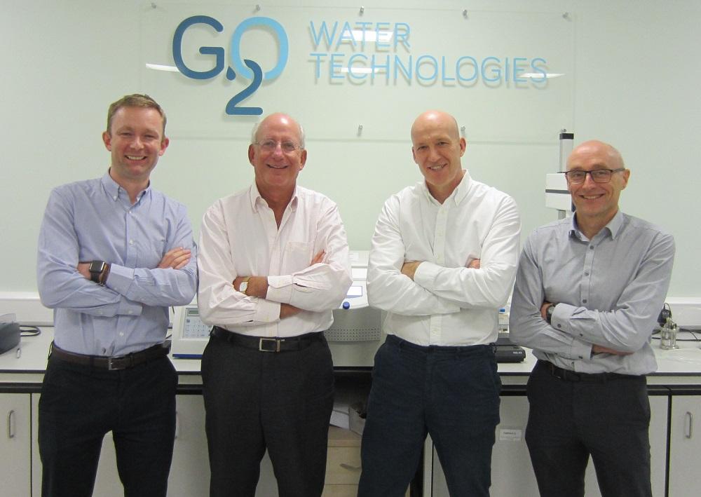 4 men stood with their arms crossed in an office with G20 Water Technologies logo on the wall behind them