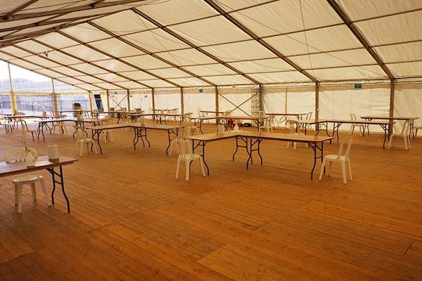A marquee with tables and chairs and a wooden floor