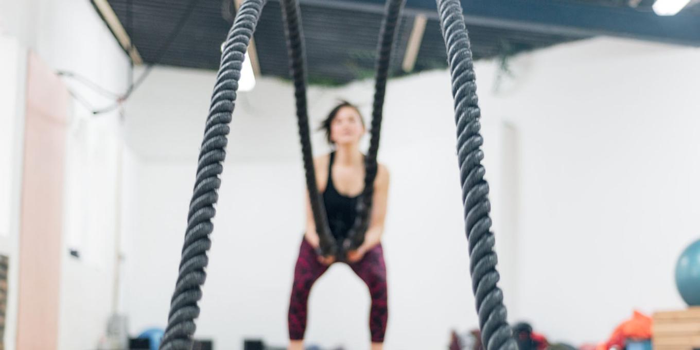 A women holding battle ropes in a gym studio