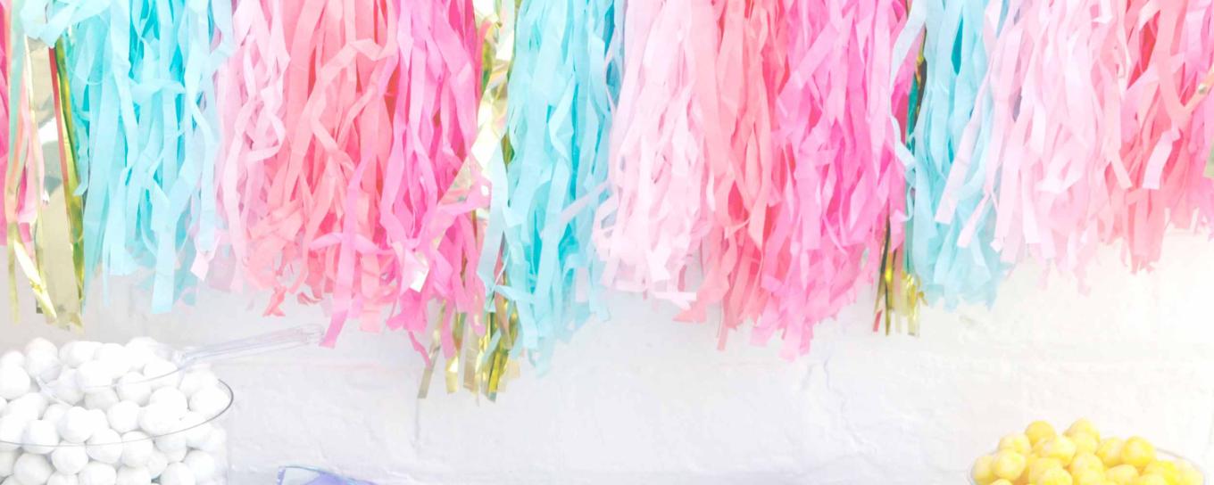 Decorative shredded tissue paper in a variety of colours hanging from the wall