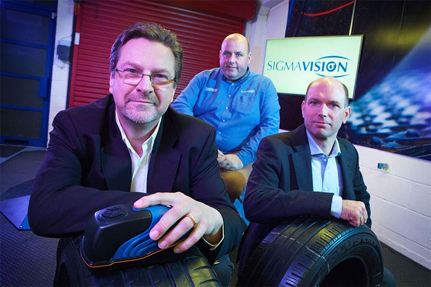 Three men from Sigma Vision sat in an office with some tyres