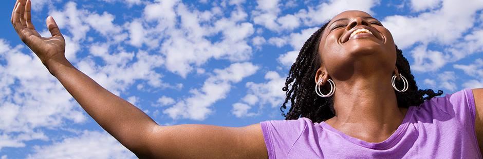 Woman in a purple t-shirt smiling looking up to the sky