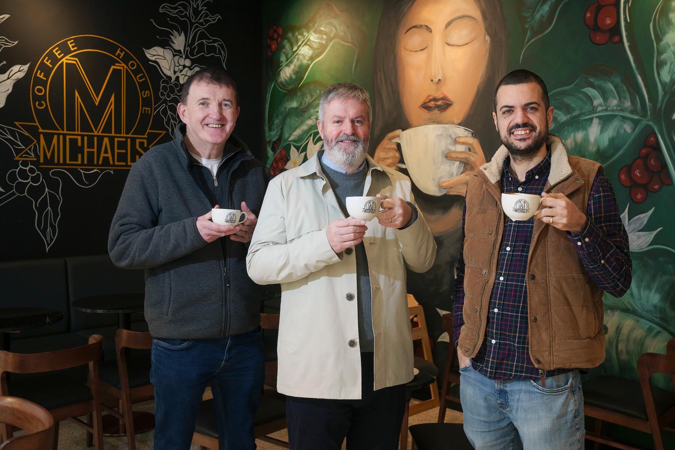 image of three men standing in front of michaels coffee house